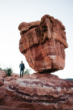 Young Man Standing Under Balance Rock In Garden Of The Gods