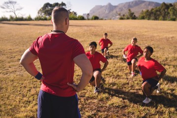 Wall Mural - trainer instructing kids while exercising in the boot camp