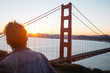 © Jesse Morrow/Stocksy - young male in front of golden gate bridge looking away from camera towards city