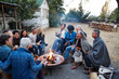 © Trinette Reed/Stocksy - Group of friends and family relaxing around a fire pit at a farm