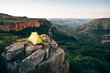 © Micky Wiswedel/Stocksy - Hiker and her tent on a rocky outcrop overlooking a scenic valler