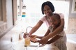 © WavebreakMediaMicro - Smiling mother assisting daughter while washing hands in bathroom at home