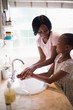 © WavebreakMediaMicro - Mother looking at daughter while washing hands in bathroom