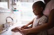 © WavebreakMediaMicro - Mother assisting daughter while washing hands at bathroom sink