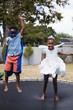 © WavebreakMediaMicro - Playful siblings in costumes jumping on trampoline