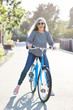 © Trinette Reed/Stocksy - Portrait of stylish mature woman with grey hair riding a bike