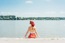 Young Woman Enjoying A Sunny Day At The River Bank