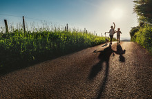 Mother, Son And Dog Walk On Country Sunset Road And Make Funny Cartoon Shadows