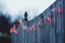 Twinkle Lights Hanging From A Fence
