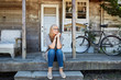 © Trinette Reed/Stocksy - Portrait of mature woman in front of farmhouse cottage