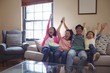 © WavebreakMediaMicro - Smiling family watching television together in living room