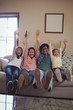 © WavebreakMediaMicro - Smiling family watching television together in living room