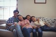 © WavebreakMediaMicro - Smiling family relaxing on sofa in living room