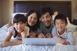 © wavebreak3 - Family using laptop together in bedroom at home