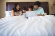 © wavebreak3 - Family using laptop together in bedroom