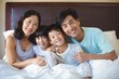 © wavebreak3 - Family sitting together in bedroom