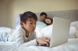 © wavebreak3 - Boy using laptop in bedroom