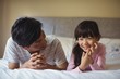 © wavebreak3 - Father and daughter lying together in bedroom