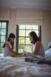 © WavebreakMediaMicro - Daughter and mother playing with teddy bear in bed room