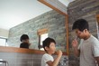 © wavebreak3 - Father and son brushing teeth together in bathroom