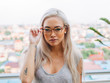 © Jesse Morrow/Stocksy - Young asian female model wears glasses on rooftop