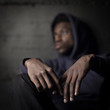 © Robert Kohlhuber/Stocksy - Sad black man in front of grunge wall