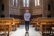 © Jesse Morrow/Stocksy - Portrait of young man in library on college campus