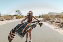A Carefree Young Woman Stands In The Middle Of A Desert Road