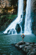 © Micky Wiswedel/Stocksy - Hiker with backpack standing in front of a scenic waterfall