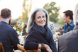 © Trinette Reed/Stocksy - Portrait of senior woman with group of friends enjoying a Farm To Table Dinner Party in backyard