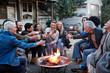 © Trinette Reed/Stocksy - Group of friends and family relaxing around a fire pit at a farm