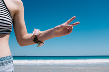 Girl At Beach Making Peace Sign With Her Fingers
