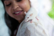 © Saptak Ganguly/Stocksy - A pet white mouse sitting on the shoulder of a girl