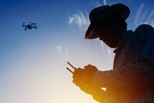 Silhouette Of Farmer Using Drone Remote Control