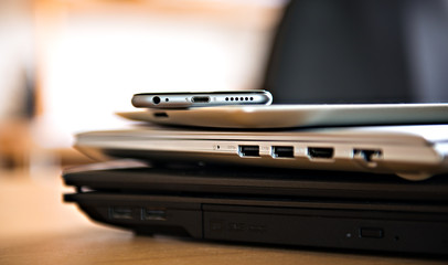 pile of different computers and phone