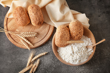 Sticker - Bowl of wheat flour and fresh bread on dark table, top view