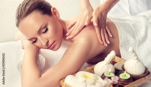 Zdjęcie XXL Masaż i pielęgnacja ciała. Zabieg masażu ciała. Kobieta o masaż w salonie spa dla pięknej dziewczyny
