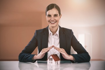 Poster - Composite image of insurer protecting a house by his hands