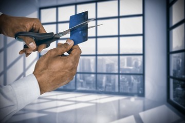 Poster - Composite image of businessman cutting credit card with scissors