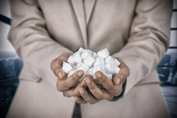 Poster - Composite image of womans hands cupped with sugar cubes