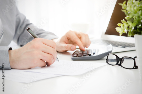 Fotografía Accountant calculates tax. Working in the office with calculator