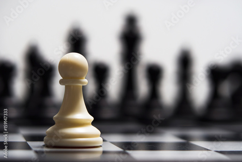 Fotografie, Obraz White pawn against the background of dark chess pieces