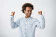 © wayhome.studio  - Excited African male winner raising his fists with great happiness having good mood after winning game. Young champion having success being glad to achieve his goals. Victory and triumph concept