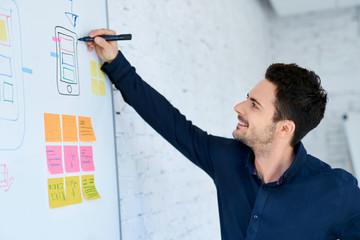 Designer prototyping mobile application layout on whiteboard