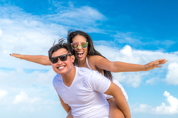 Asian couple having fun on the beach of tropical Bali island, Indonesia.