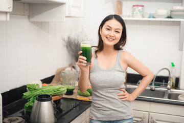 Wall Mural - Young asian woman enjoy healthy vegetarian smoothie for weight loss and detox