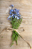 Fototapeta  - Forget me nots flowers with ribbon on a dark wooden background, copy space