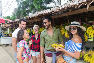 Wall Mural - People Group Buying Bananas On Street Traditional Market, Young Man And Woman Travelers Choosing Fresh Fruits