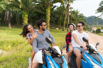 Wall Mural - two couple riding motorbike, young man and woman travel on bike on tropical forest road during exoti