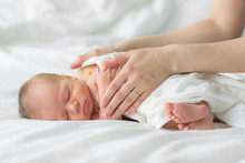 Newborn Baby Sleeping On A Blanket. Mother Gently Strokes Her Child's Hand